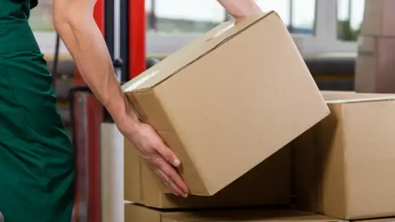 Hands of warehouse worker lifting box%2c horizontal.jpeg