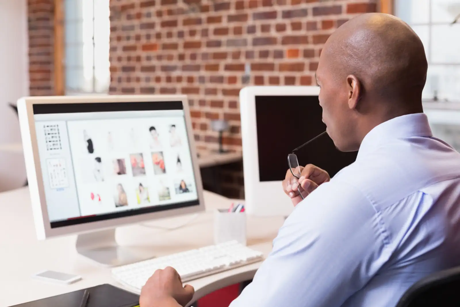 Young businessman looking at computer monitor in office.jpeg