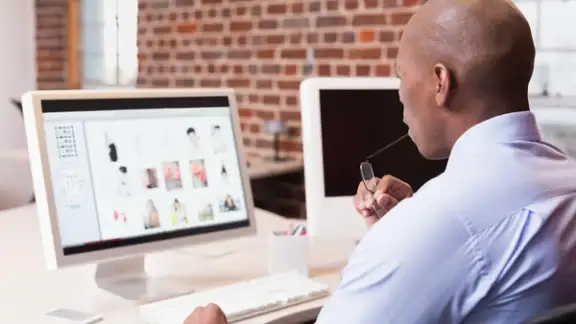 Young businessman looking at computer monitor in office.jpeg