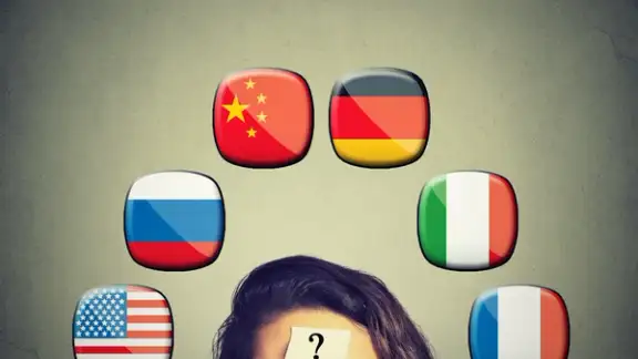Work and travel immigration opportunity concept. Foreign language studying process. Woman with question mark and icons of international flags above head isolated on gray wall background..jpeg