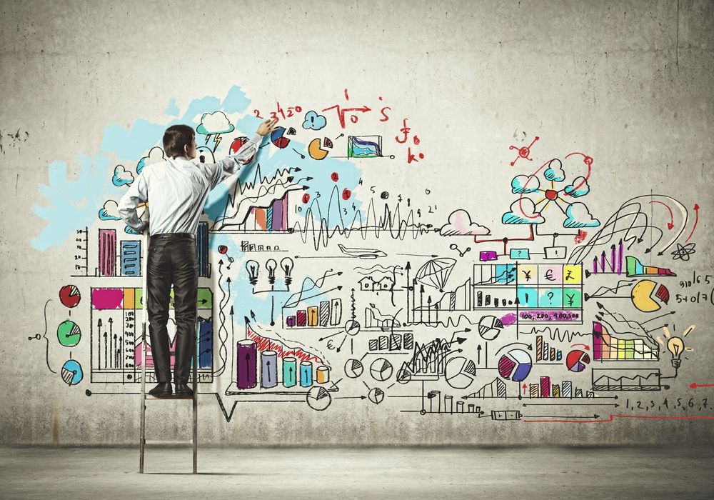 Back view of businessman drawing sketch on wall.jpeg