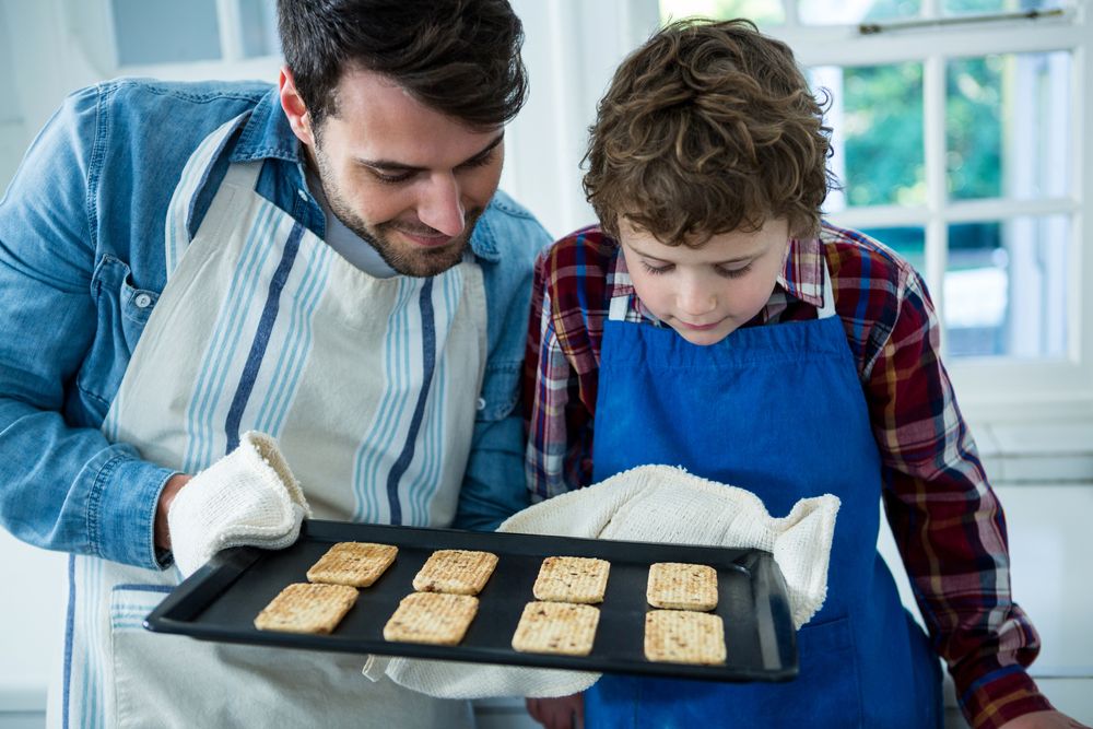 Father holding biscuits tray in the kitchen.jpeg