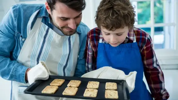 Father holding biscuits tray in the kitchen.jpeg