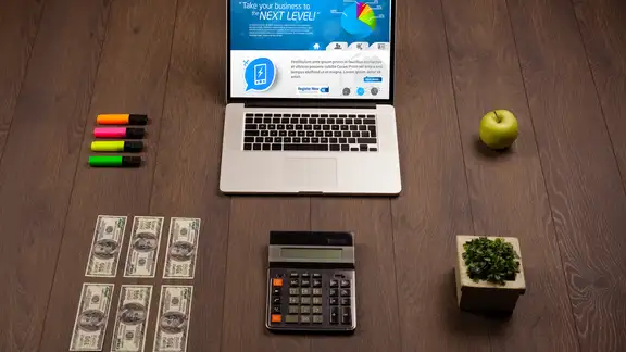 Laptop on office wooden desk with business website on screen.jpeg