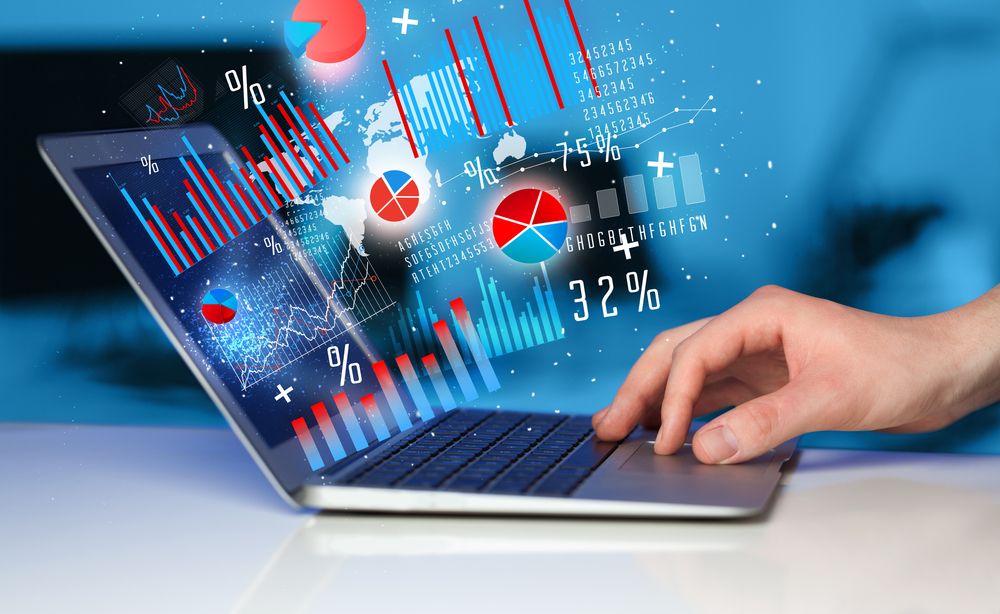 Hand typing on modern laptop notebook computer with future graph icons and symbols.jpeg