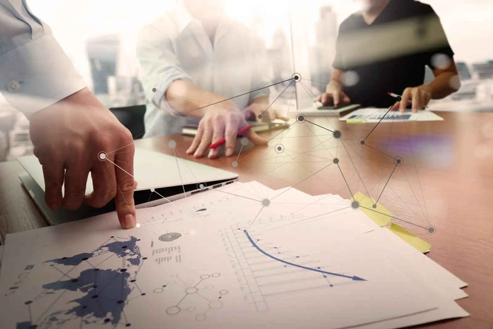 business documents on office table with smart phone and laptop computer and graph financial with social network diagram and two colleagues discussing data in the background.jpeg
