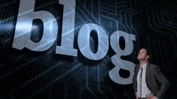 The word blog and serious businessman with hands on hips against futuristic black and blue background.jpeg