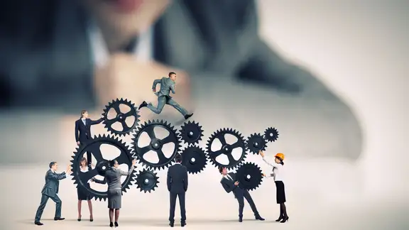 Businesswoman looking at team of businesspeople in miniature.jpeg