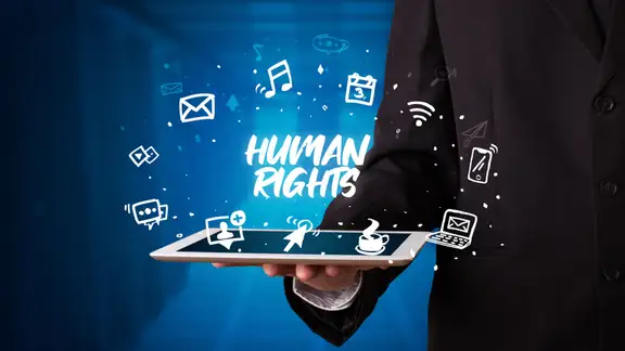 Young business person working on tablet and shows the inscription HUMAN RIGHTS.jpeg