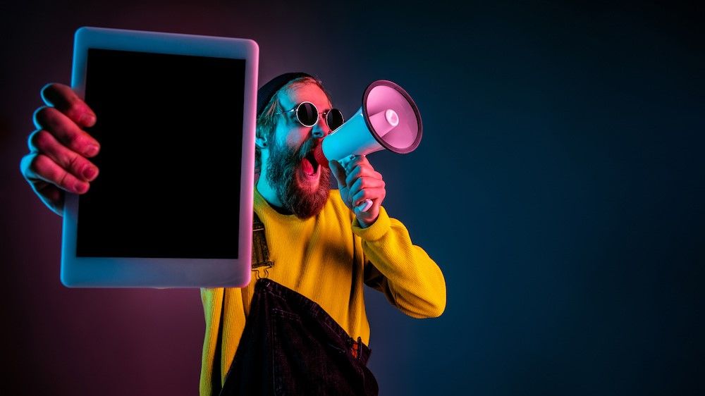 persona mostra tablet con un megafono in mano.jpg