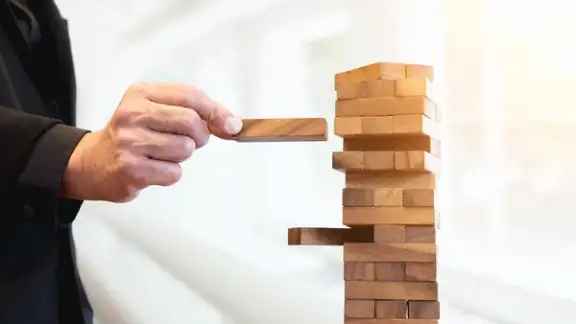 uomo mette tassello su costruzione in legno.jpg