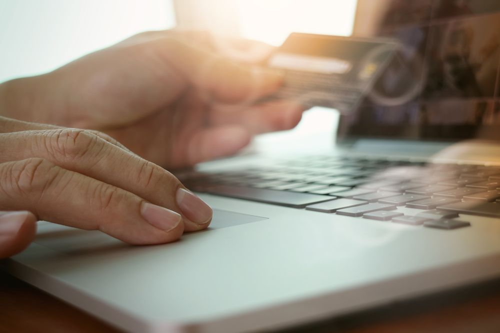 close up of hands using laptop and holding credit card  as Online shopping concept.jpeg