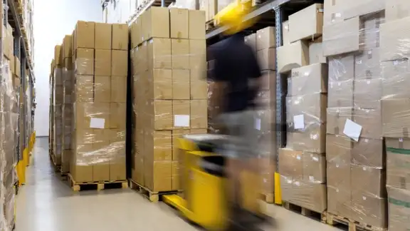 Fork lift with operator working in warehouse.jpeg