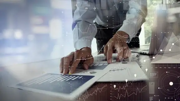 close up of businessman hand working on laptop computer with financial business graph information diagram on wooden desk as concept.jpeg