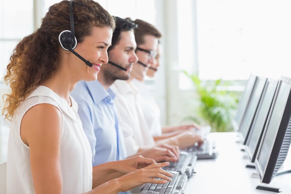 Customer service representatives working at desk in office.jpeg