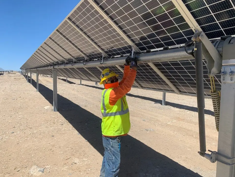 Worker who is making adjustments to solar panels