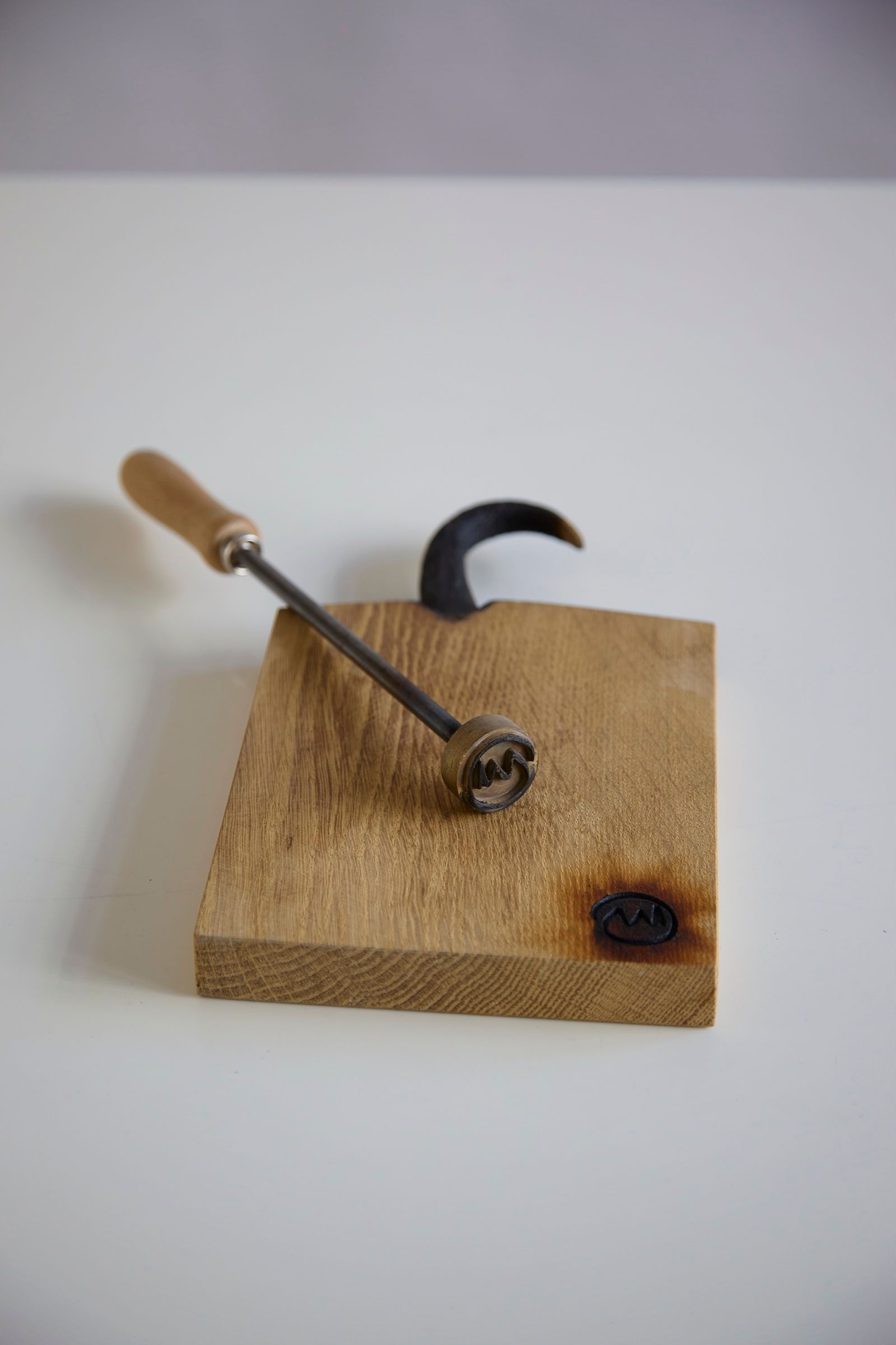 Brandeisen mit Brandzeichen auf einem Holzstück