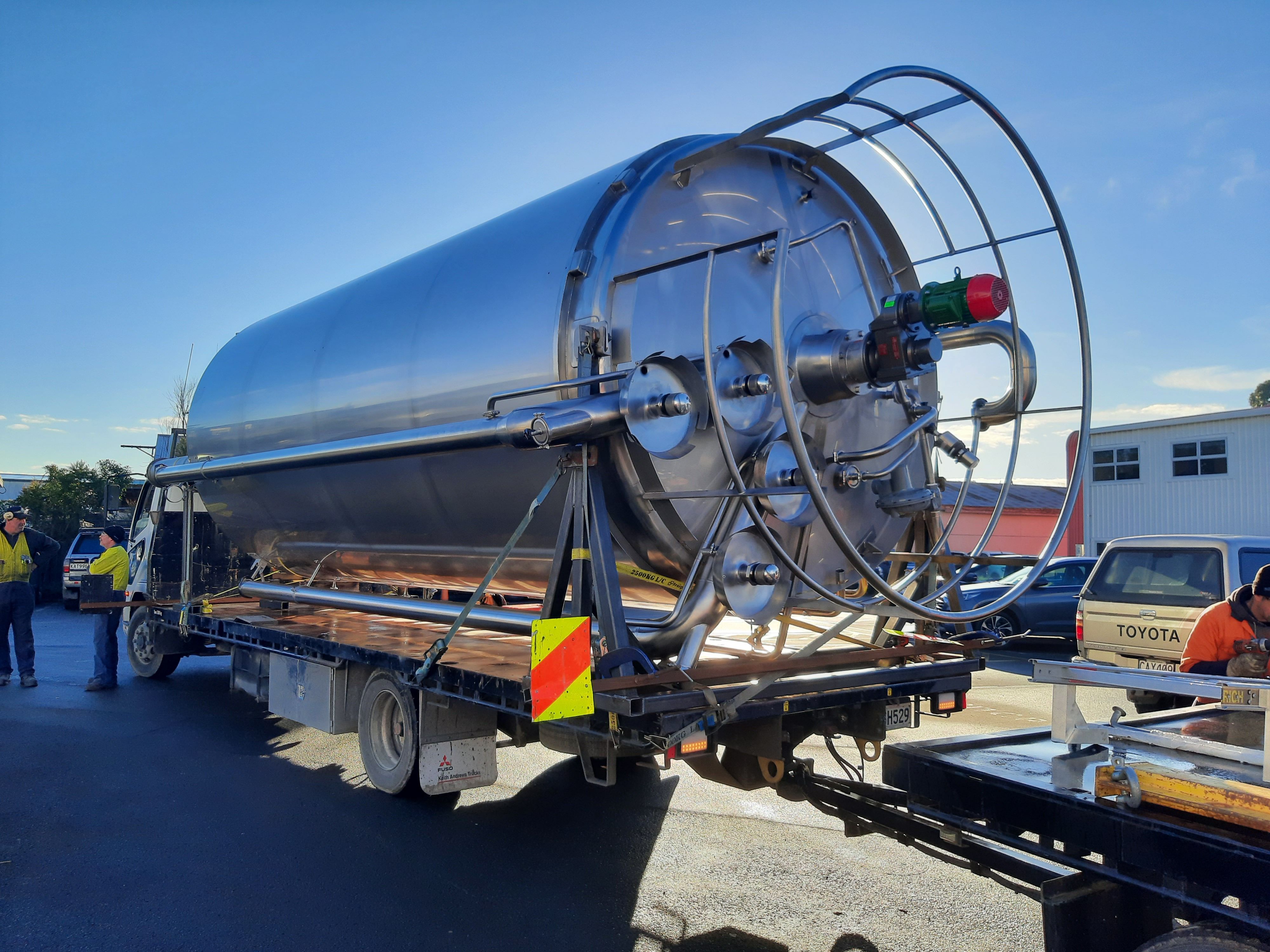 A Longveld metal silo laying horizoontally on the back of a truck 