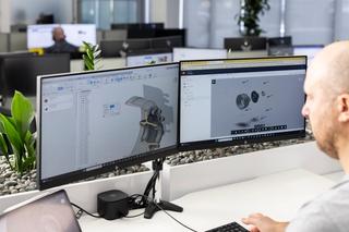A man working in front of a computer using Fusion 360 software