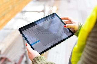 Hands holding a tablet with CAD model on the screen 