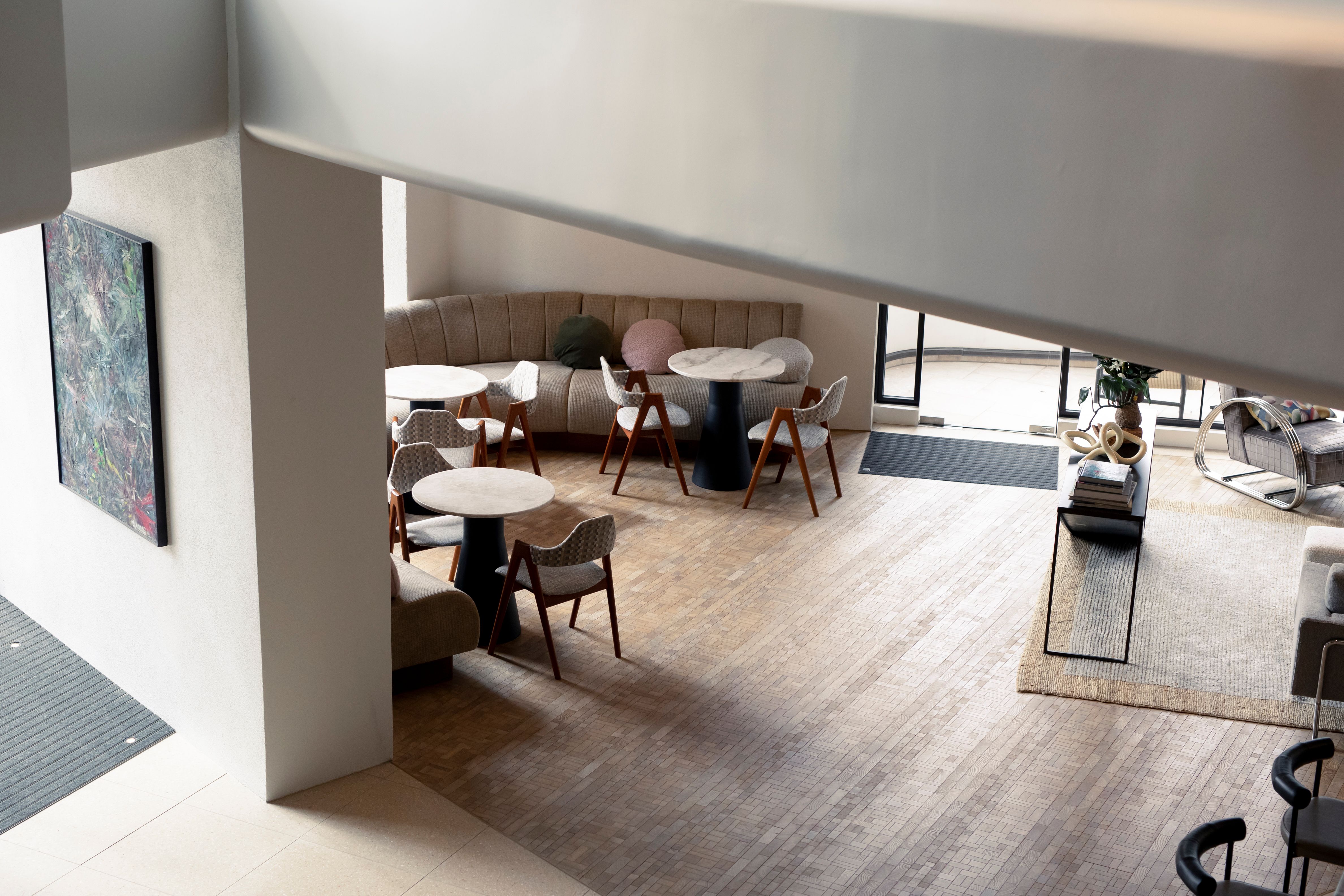 A room shot from above with tables, chairs and a wooden floor 