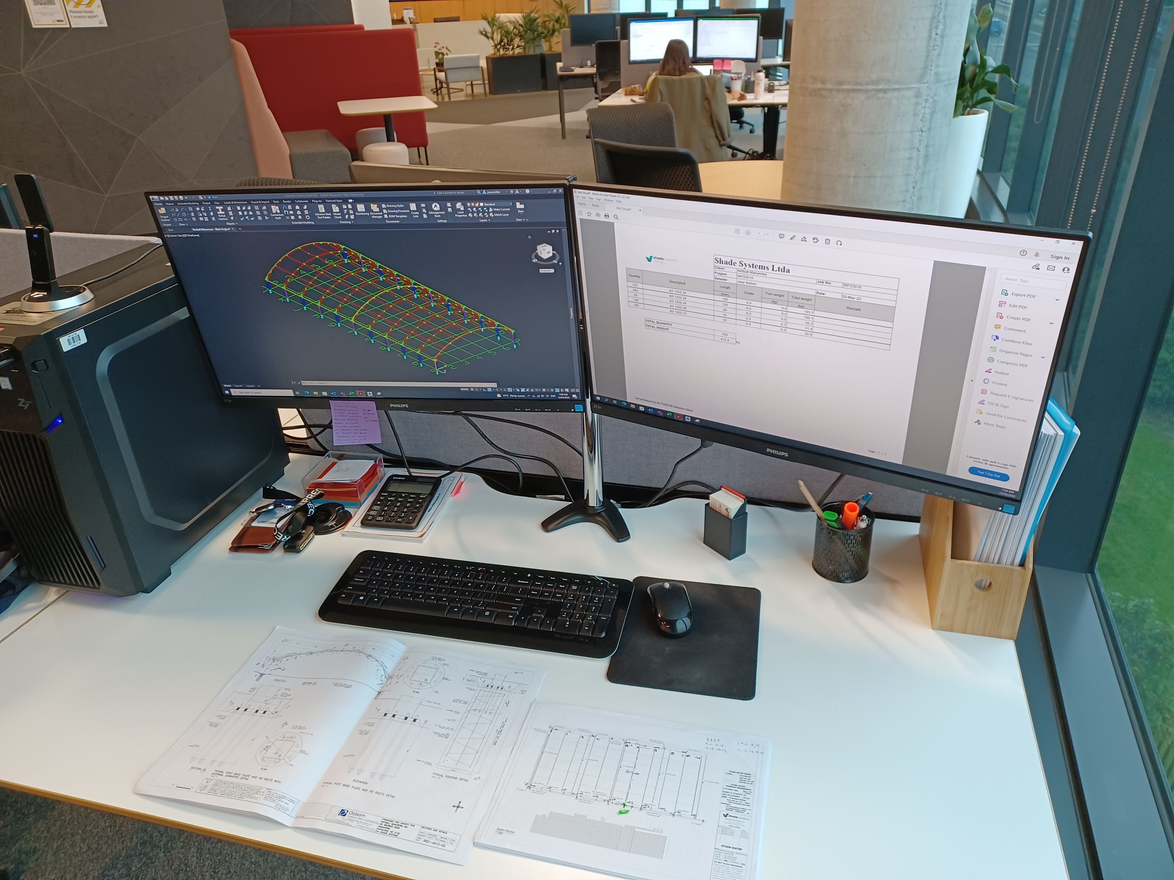 Double computer screens on a desk with an Advance Steel model on the left screen 