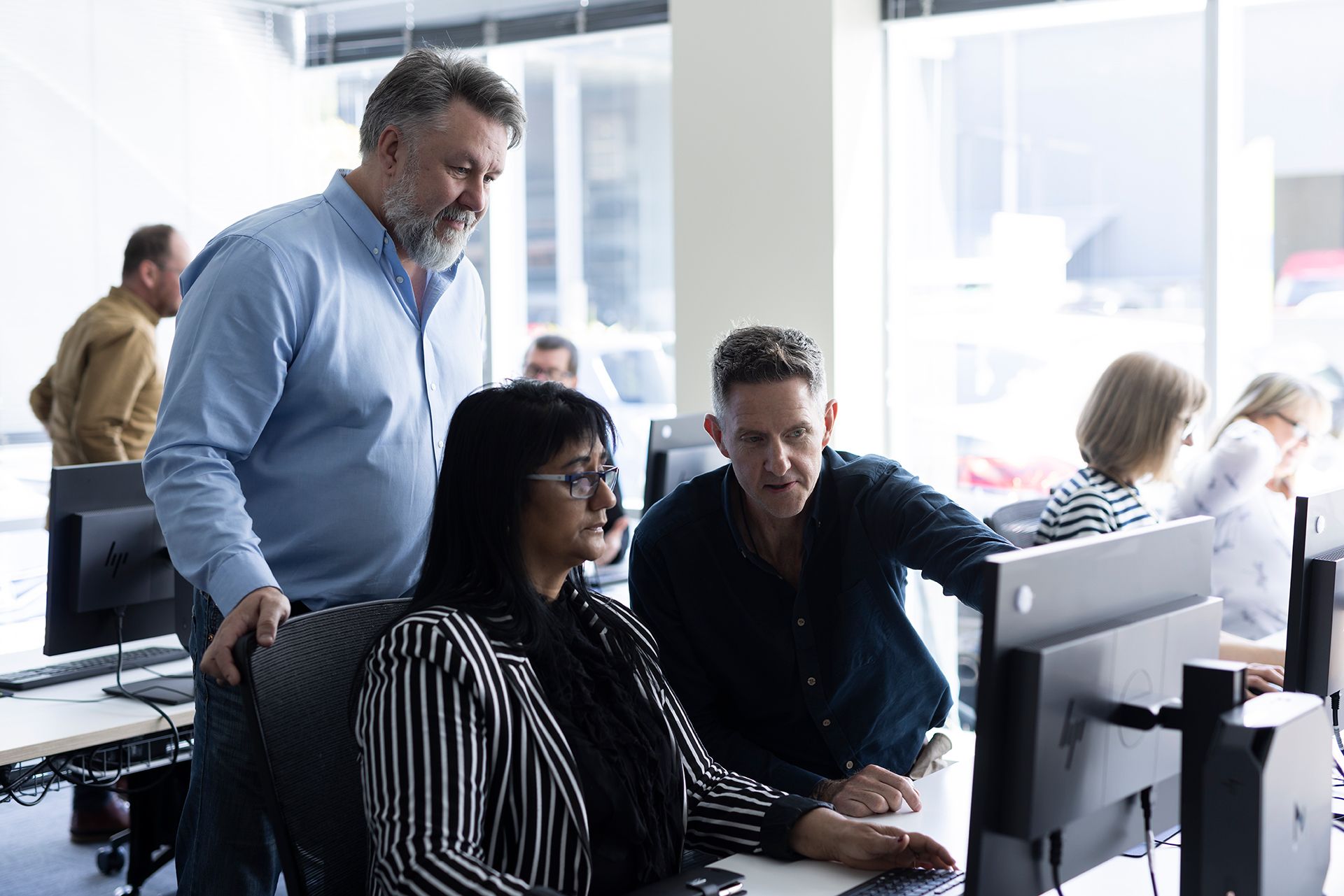 two people looking at computer with trainer offering support