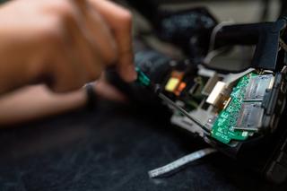 Engineer screwing a part into an electrical circuit board