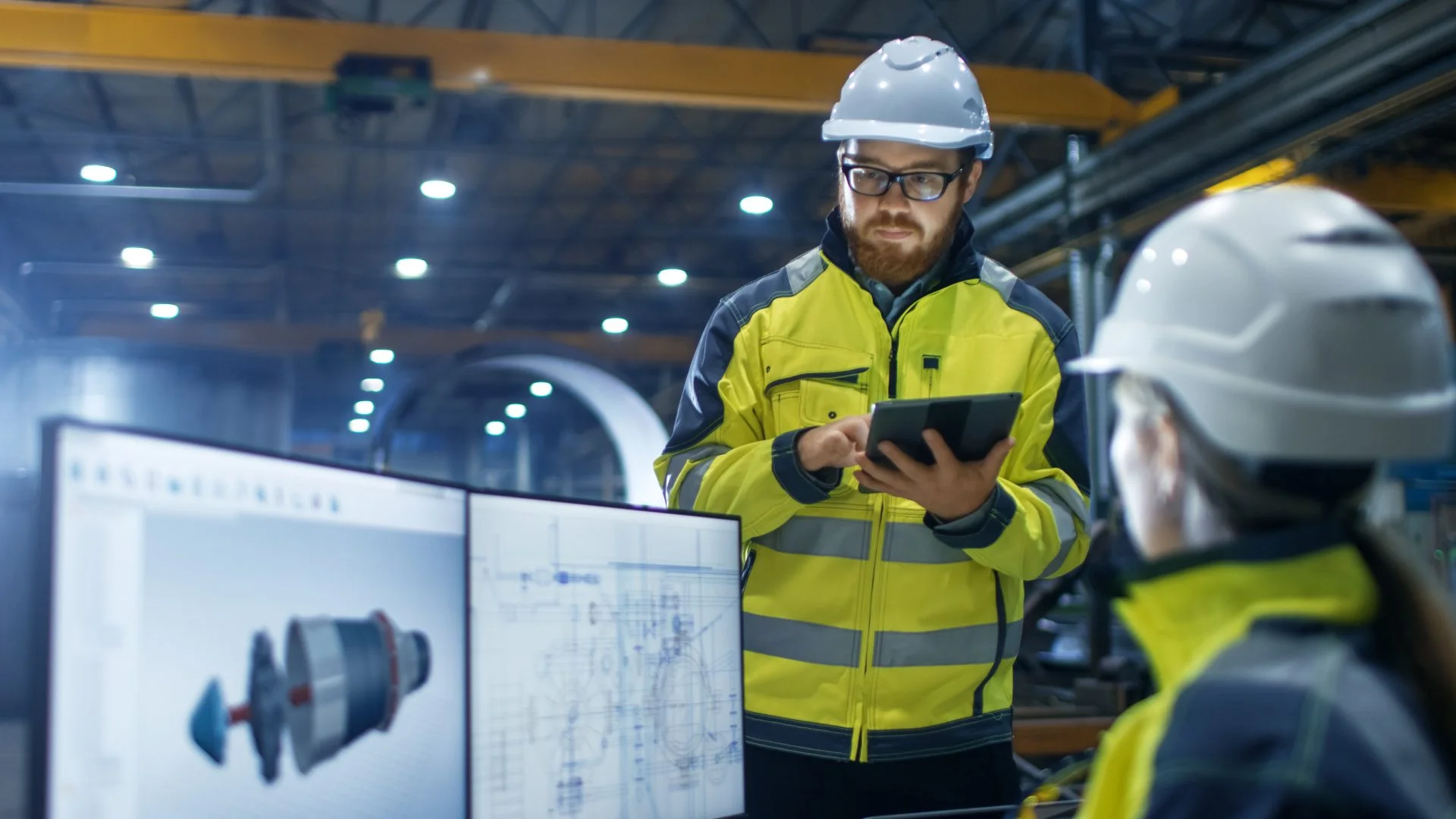 People are working in a workshop with their computer and tablet.