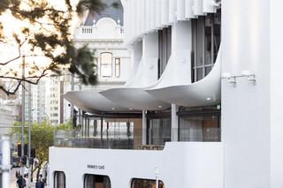 Facade of a white building in downtown Auckland with distinct scooped window architraves 