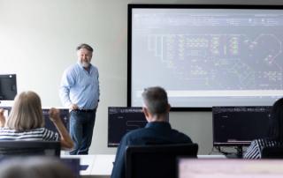 Cadpro trainer standing in front of class with AutoCAD software on a projector screen