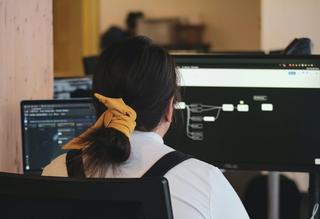 Women facing computer with yellow hair tie 