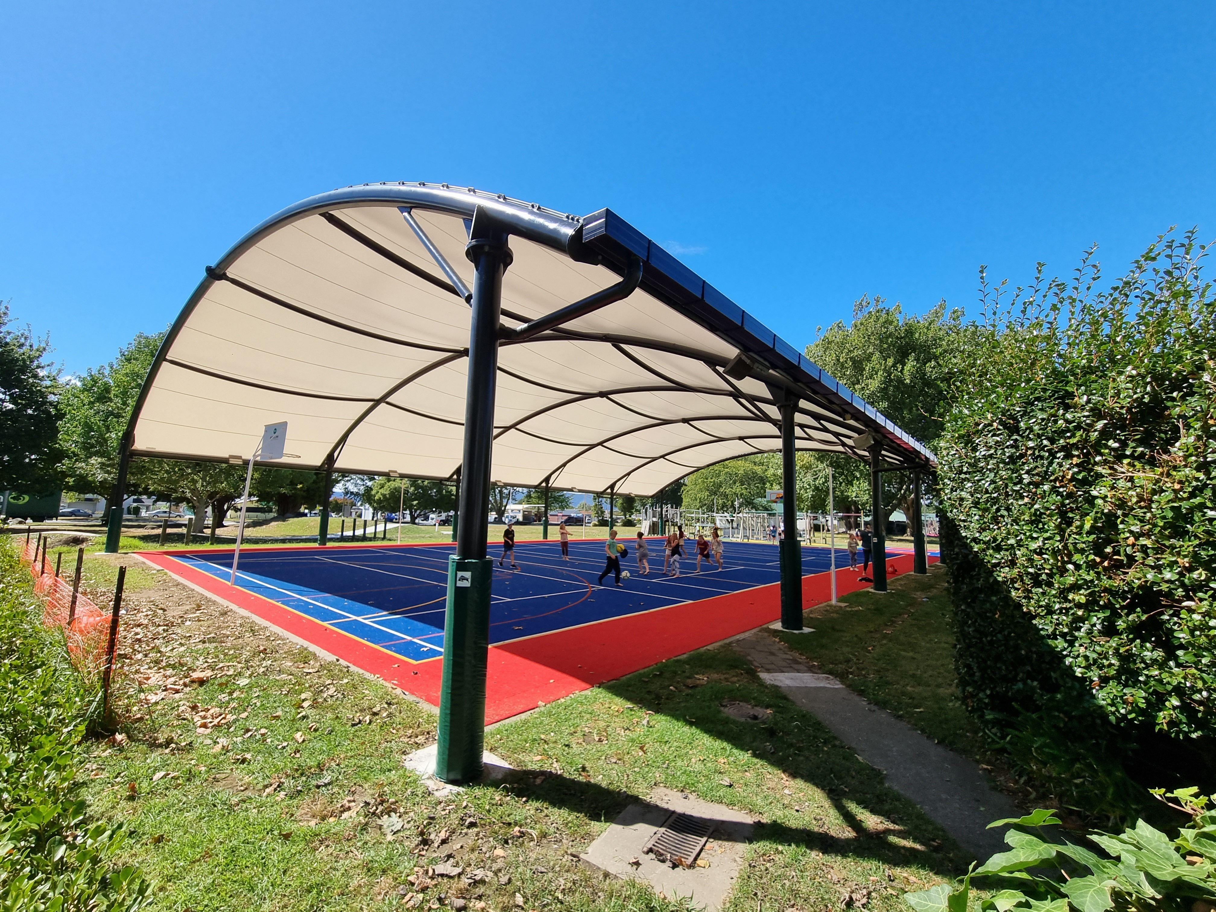 A outdoor school sports shade with children playing underneath 