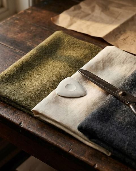 Three fabric swatches compared side by side with tailor chalk and shears
