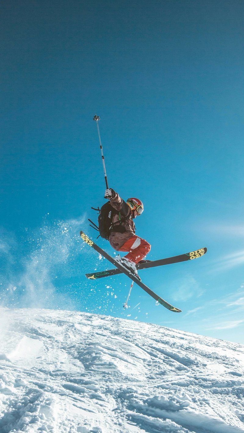 Skier carving through powder snow on alpine terrain