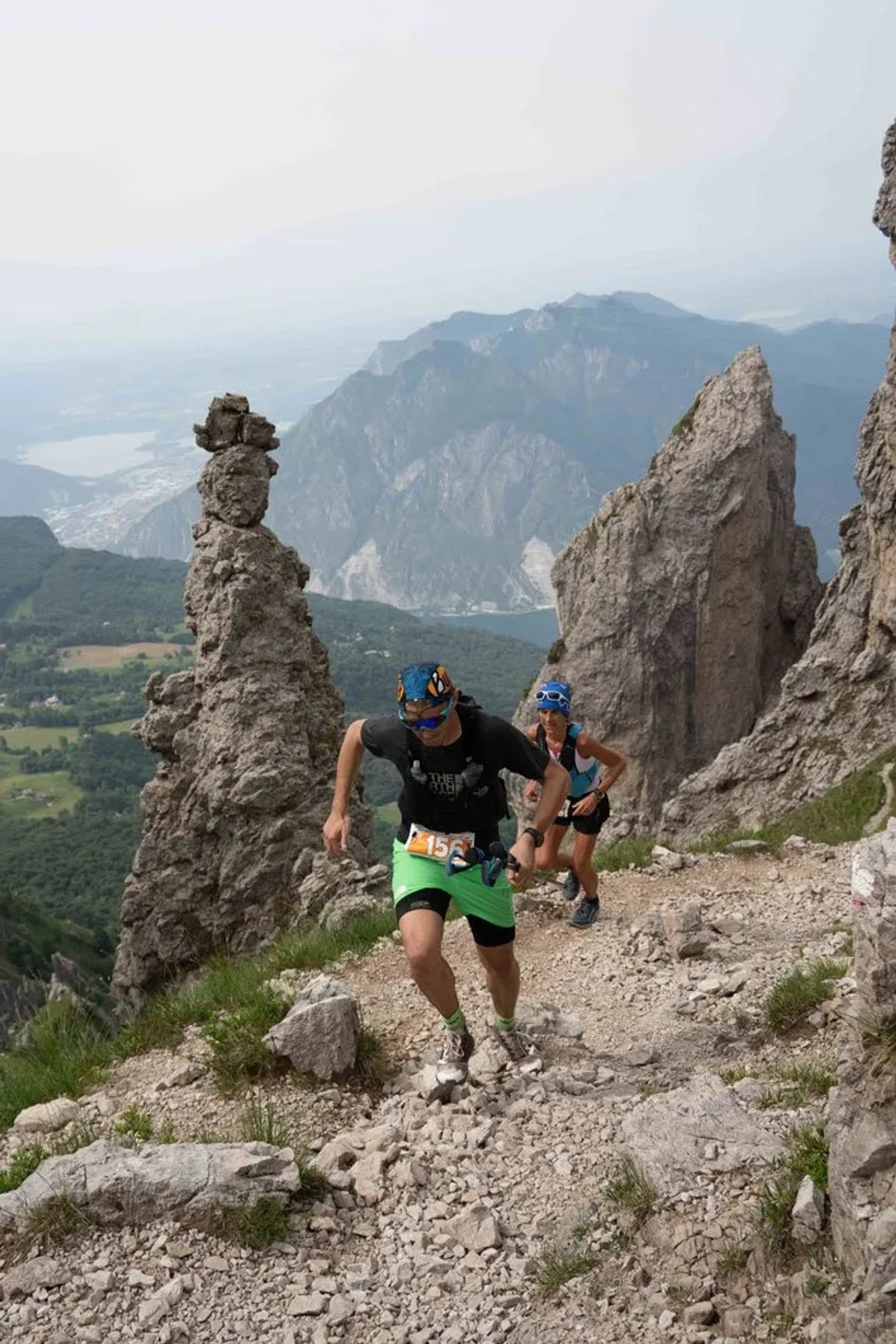 Trail runners on a rocky ridgeline high above Lake Como