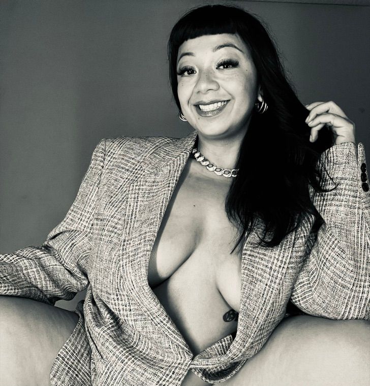 Gushy, smiling, in a checked blazer