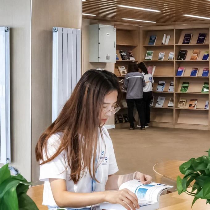 Mitarbeiter liest an einem Tisch in der Firmenbibliothek