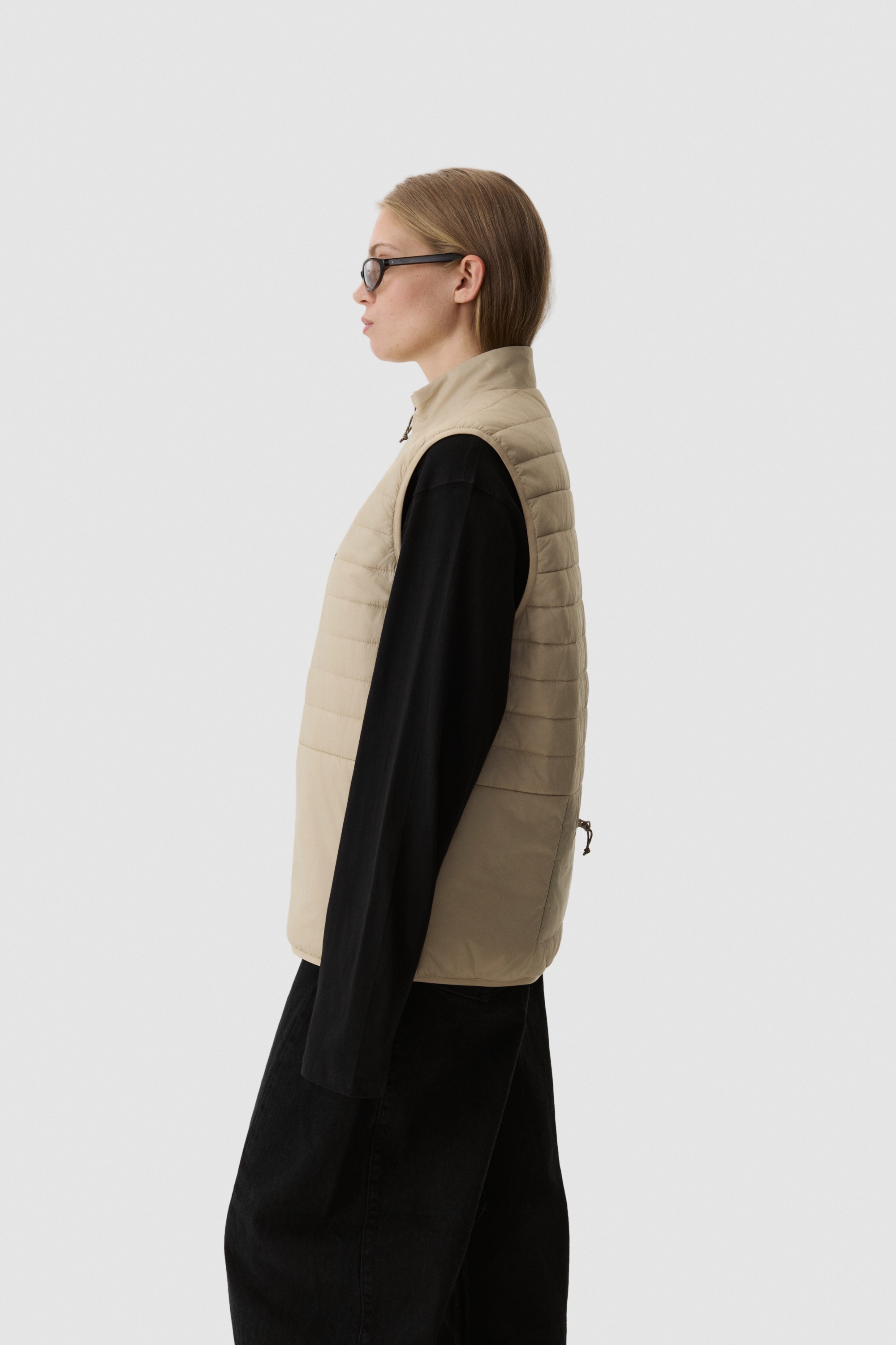 Model wearing Yama Traverse Puffer Vest Sand Dune