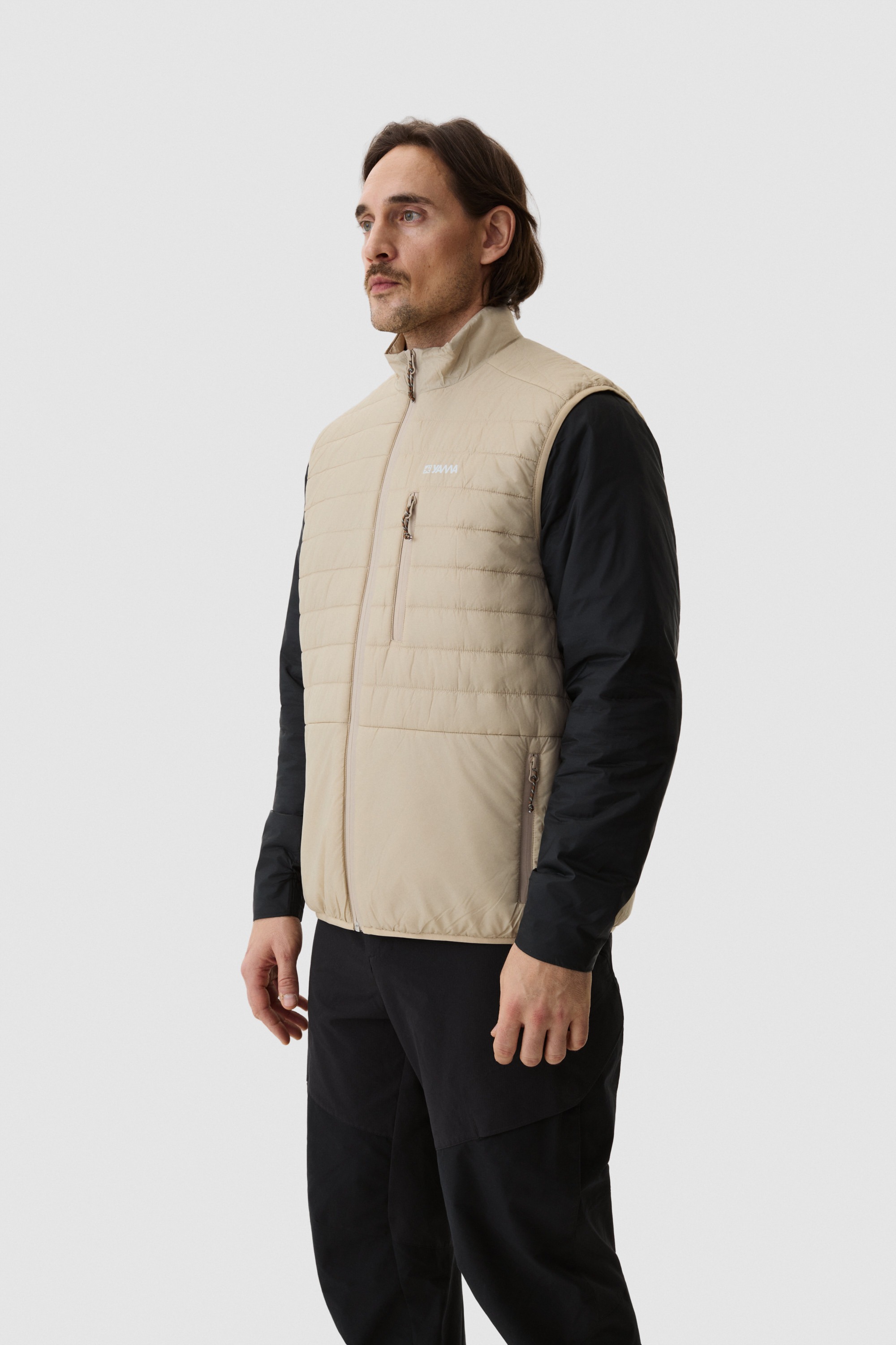 Model wearing Yama Traverse Puffer Vest Sand Dune