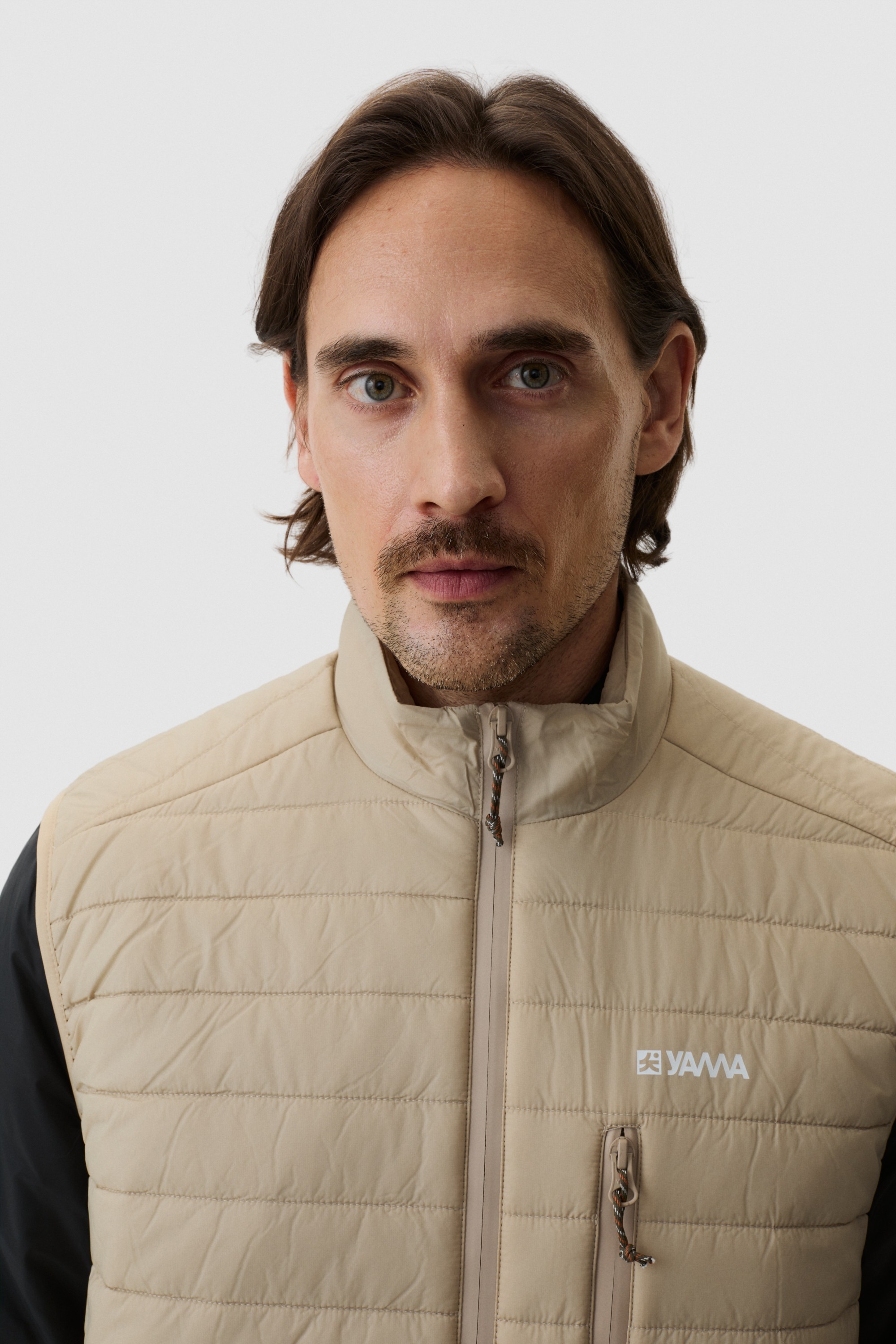 Model wearing Yama Traverse Puffer Vest Sand Dune