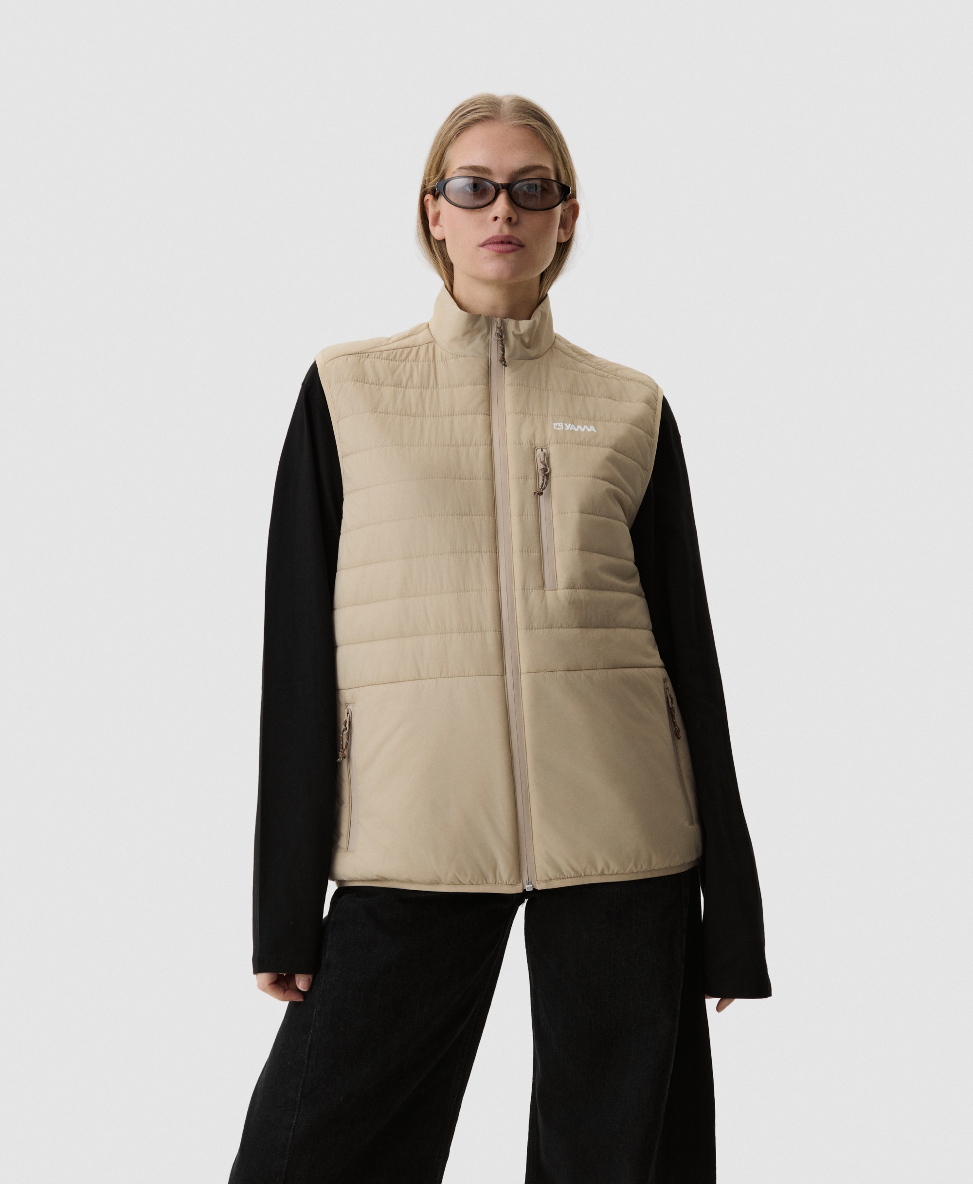 Model wearing Yama Traverse Puffer Vest Sand Dune