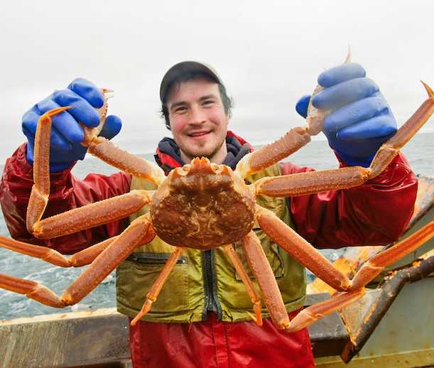 fisherman on a boat holding a crab