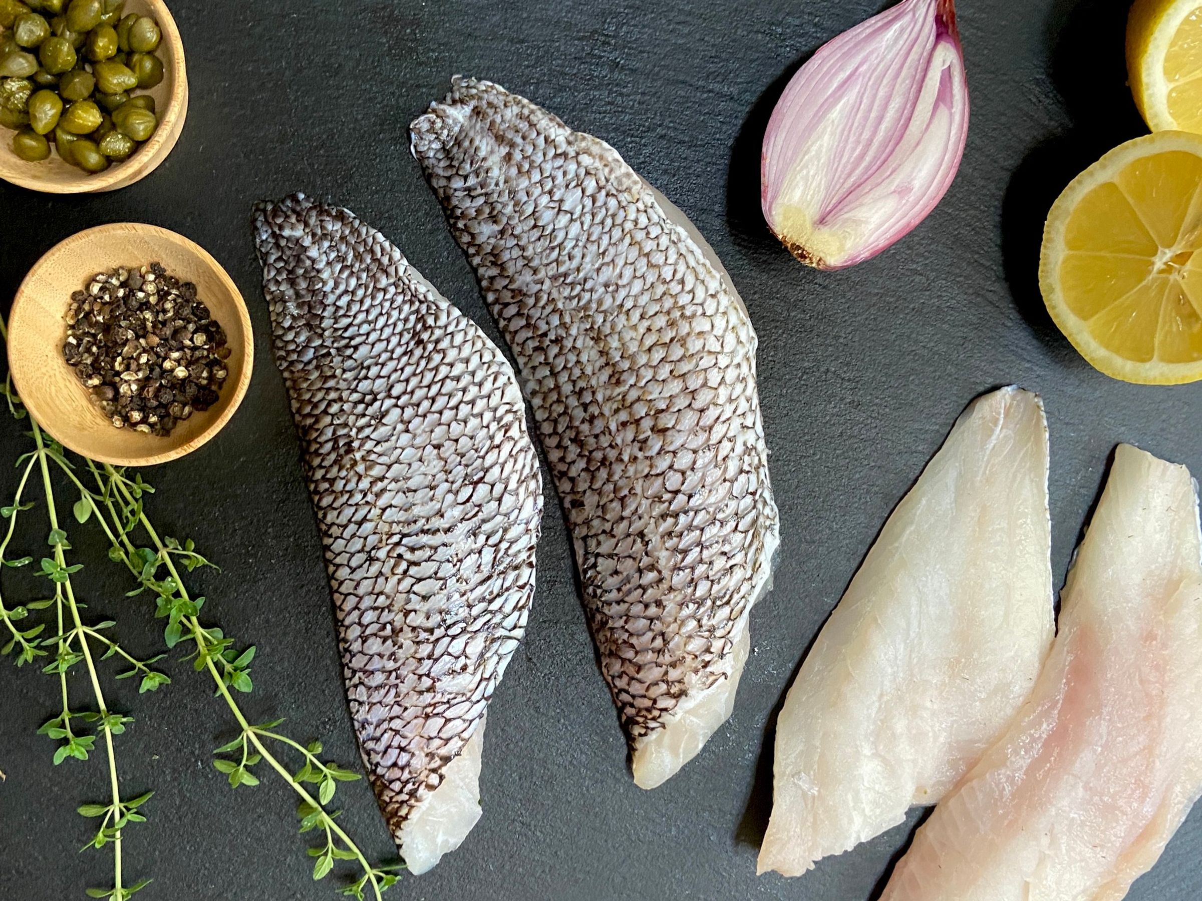 there are many different types of fish and vegetables on the table .