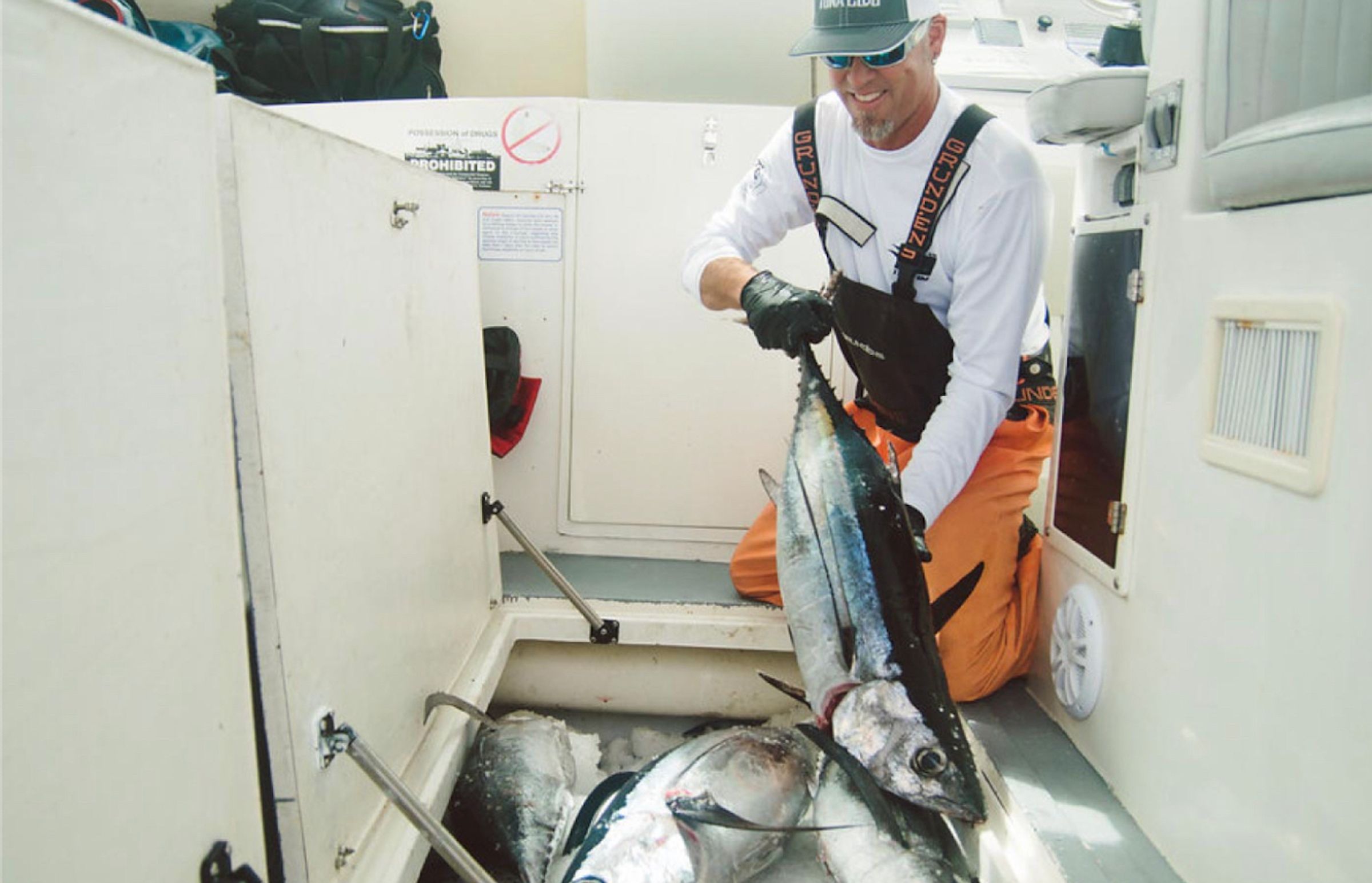 a piece of meat is sitting on a black cutting board surrounded by spices .