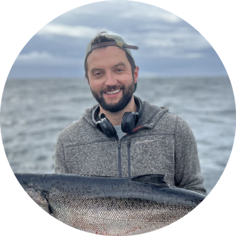 a man wearing headphones is holding a large fish