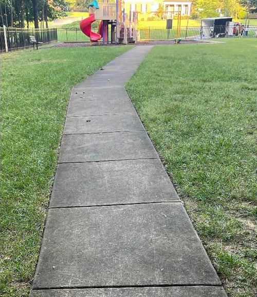 A View of the Sidewalk Heading Out of the Playground Full of Filth.