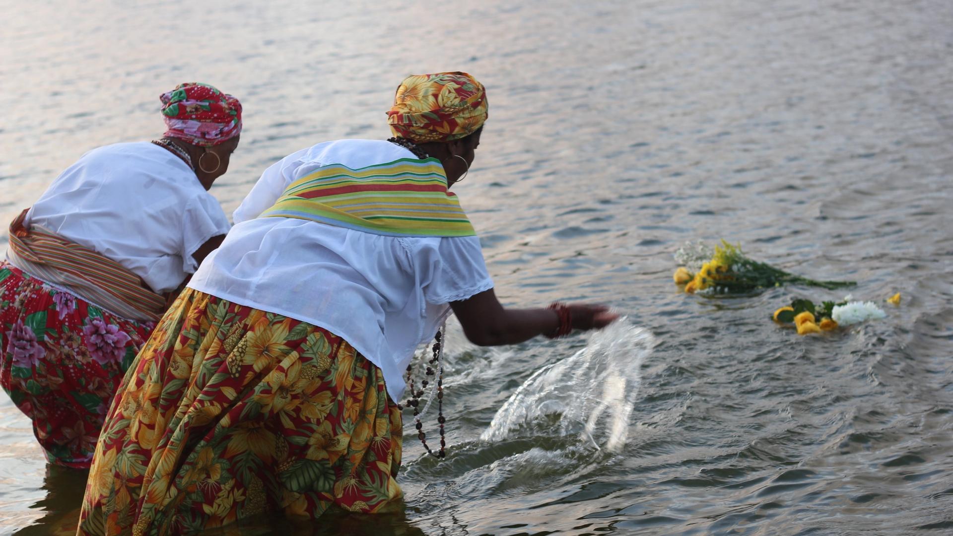 Duas Ganhadeiras de Itapuã lançam oferendas de flores ao mar
