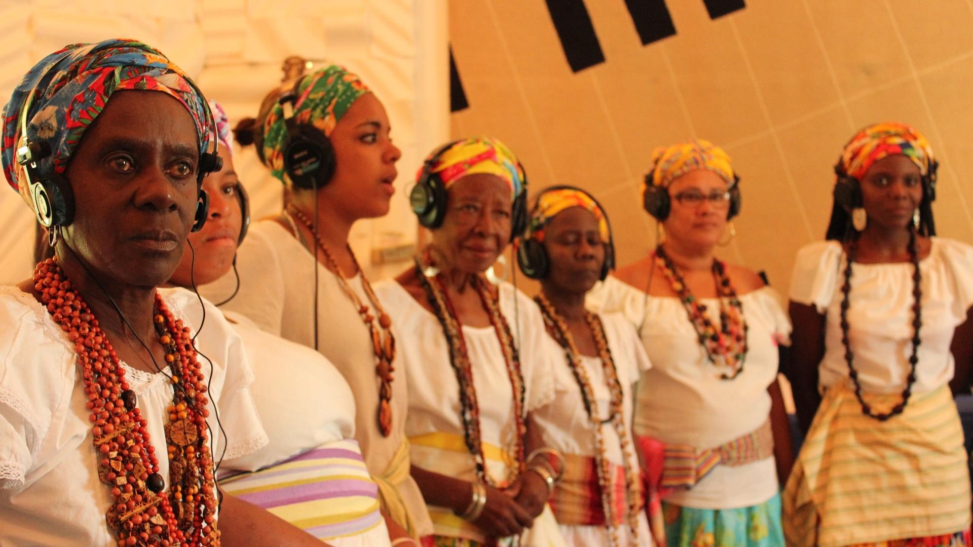 Ganhadeiras de Itapuã com fones de ouvido no Estúdio Coaxo de Sapo