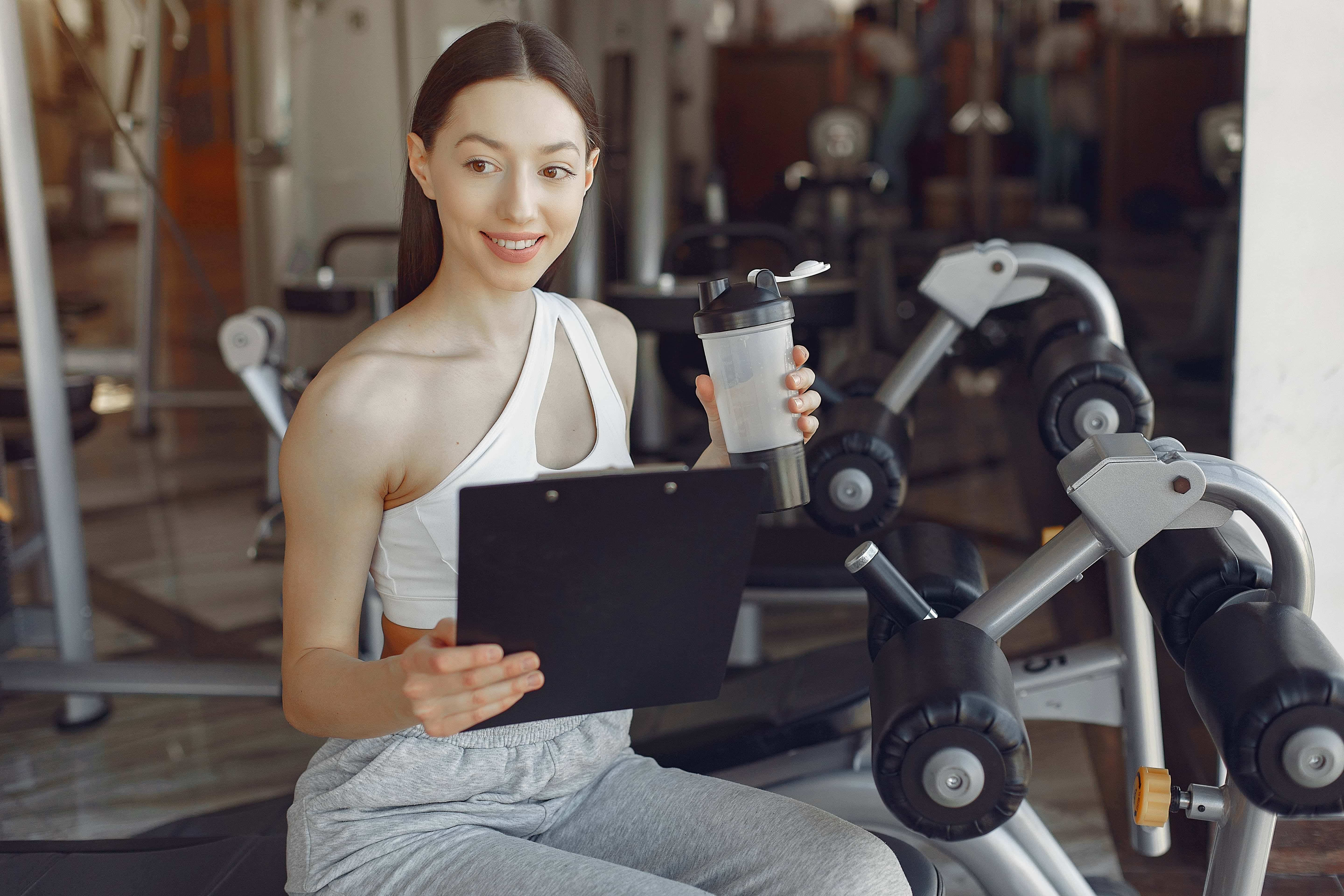 A beautiful girl sitting with water in a gym